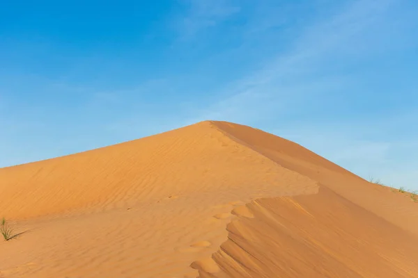 Woestijn contrast van oranje gekleurd zand en heldere blauwe lucht in de glooiende heuvels in Ras al Khaimah, in de Verenigde Arabische Emiraten. — Stockfoto