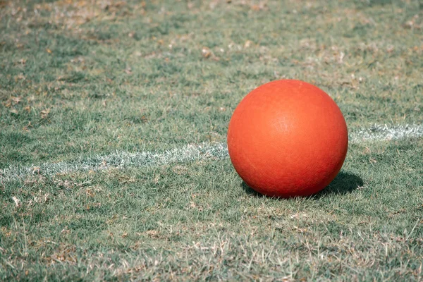 Red Playground Ball Sits Next White Line Green Grass Field — Stock Photo, Image