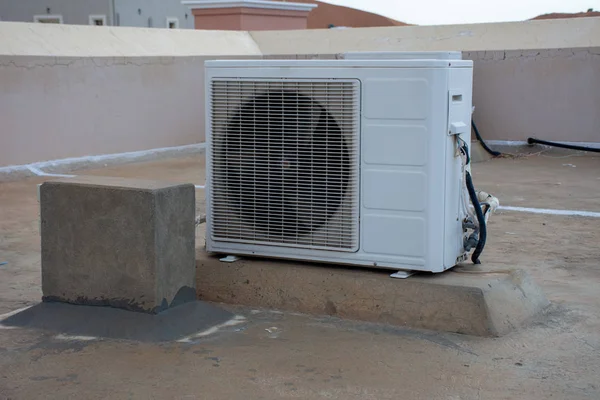 Exterior air conditioner unit on the top of a residential house roof. Construction, DIY, hot weather, industrial systems, concepts.