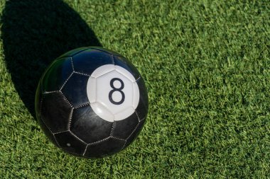 Siyah 8 (8) bilardo topu ya da bilardo topu yeşil çimlerin üzerinde gölge ve kopya alanı ile. Spor, eğlence ve çocukluk eğlencesi kavramı.