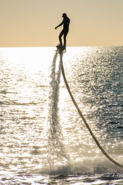 Gün batımında Dubai yakınlarındaki Birleşik Arap Emirlikleri 'nde Ras al Khaimah' da ekstrem su sporlarında uçmak ve suda eğlenmek. Eğlence ve spor kavramları.