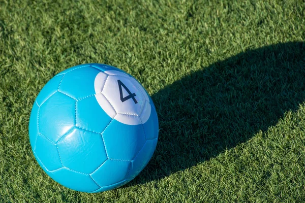 Blu numero 4 biliardo di calcio o palla da biliardo su erba verde con un'ombra e copiare lo spazio. Concetto di sport, ricreazione e divertimento infantile . — Foto Stock