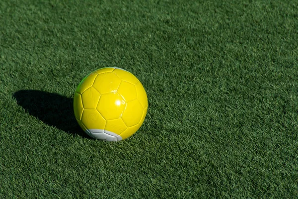 Φωτεινό κίτρινο μπιλιάρδο ποδοσφαίρου ή μπάλα πισίνα στο πράσινο γρασίδι με σκιά και αντίγραφο χώρο. Έννοια του αθλητισμού, αναψυχή και παιδική χαρά. — Φωτογραφία Αρχείου