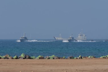 Kargaşa ve yıkımın içine uçan helikopterle askeri çatışma ve savaş. Askerler ipten yere kadar helikopterden askıya alınır. Askeri güç kavramı, güç, güç, hava saldırısı. UAQ Birlik Kalesi 7