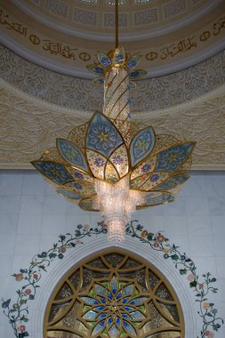 Abu Dabi, Birleşik Arap Emirlikleri 'ndeki merkez kubbede zarif cam avizelerden oluşan büyük bir Büyük Cami koridoru..