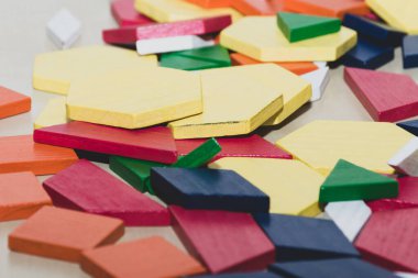 Parlak renkli tangram çocuk geometrik şekil yapboz parçaları bir yığın içinde yakın çekim.
