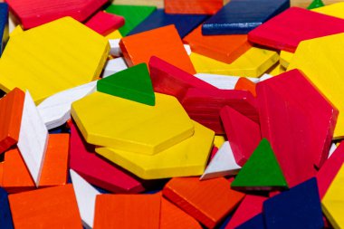 Parlak renkli tangram çocuk geometrik şekil yapboz parçaları bir yığın içinde yakın çekim.