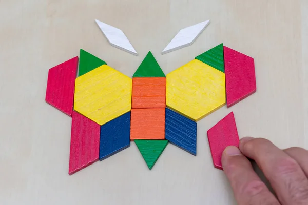 Tangram Schmetterling Farbiges Geometrisches Puzzleteil Mit Handfüllung Endstück Auf Braunem — Stockfoto