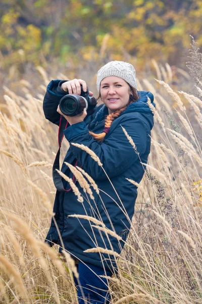 Foto van een mooi meisje met een camera in de natuur — Stockfoto