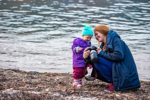 Mamma mostra alla sua figlioletta una foto sullo sfondo di un qui — Foto Stock