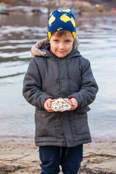 Portret van een jongetje met schelpen op de achtergrond van de Ba — Stockfoto