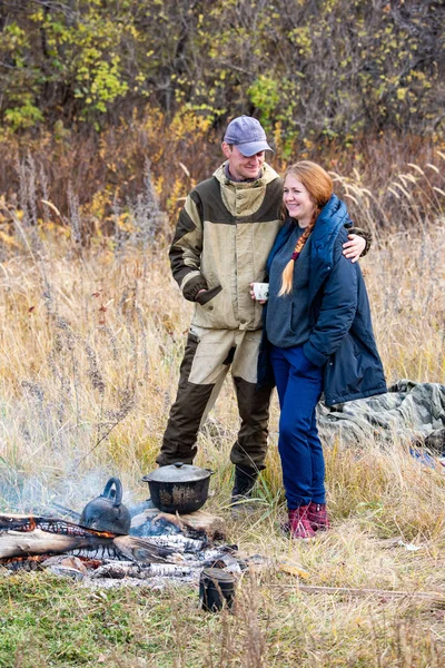 Ung man och hustru avkopplande i naturen på en ledig dag. En kittel — Stockfoto