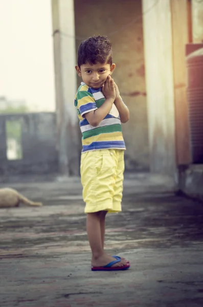Menino criança de pé olhando para os lados com dobrado mão pensando — Fotografia de Stock