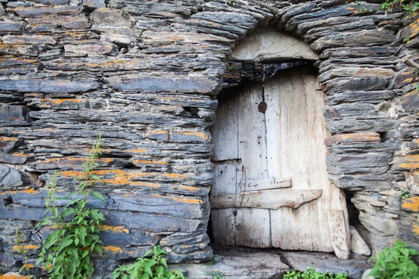 Trasig dörr på stenmur — Stockfoto