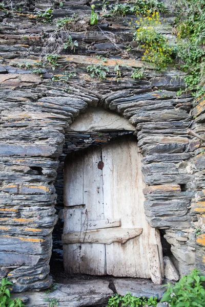 Broken door on stone wall — Stock Photo, Image