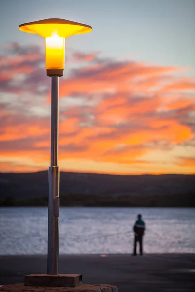 Pouliční lampy a siluetu při západu slunce — Stock fotografie