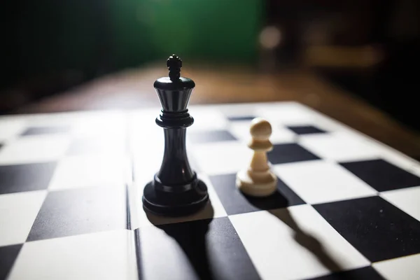 Rey negro y peón blanco en tablero de ajedrez —  Fotos de Stock