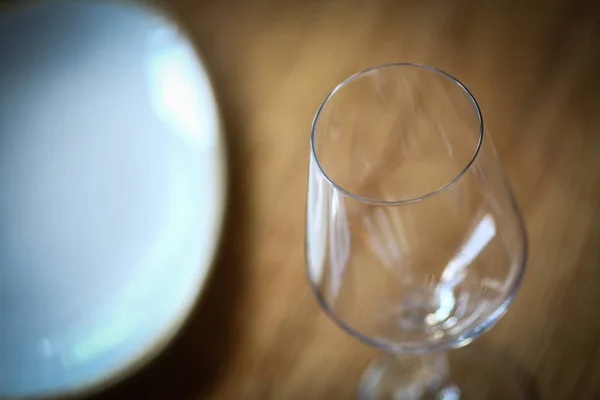 Bir masada şarap camı, bir plaka yakın — Stok fotoğraf
