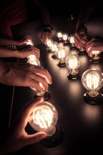 Pessoas Tocam Lâmpadas Exibidas Uma Mesa — Fotografia de Stock
