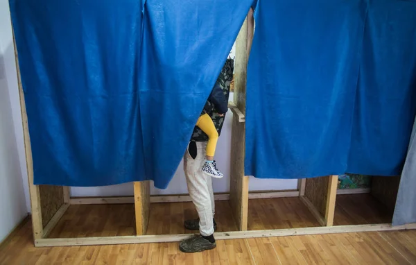 Person som röstar i bås vid röstningsställe — Stockfoto