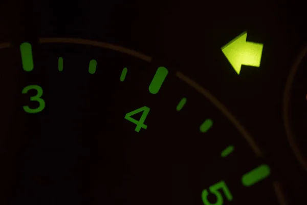 Close up shot of the turn signal icon displayed on a car dashboard.