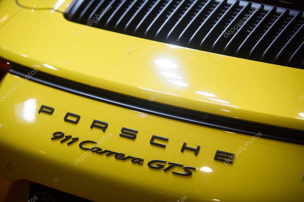 Bucharest, Romania - October 23, 2019: Illustrative editorial close up shot of the Porsche 911 Carrera GTS logo on a car. Porsche is a brand of German automobile.