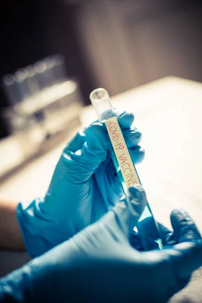 Koncepcyjny Obraz Lekarza Prowadzącego Patrzącego Tubkę Szczepionki Przeciwko Koronawirusowi Covid — Zdjęcie stockowe
