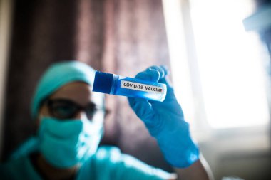 Coronavirus COVID-19 aşısı olan bir hastayı tutan bir hemşirenin kavramsal görüntüsü..