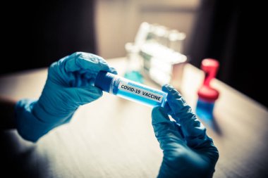 Coronavirus COVID-19 aşısı olan bir hastayı tutan bir hemşirenin kavramsal görüntüsü..