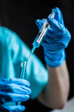 Coronavirus COVID-19 aşısıyla şırınga tutan bir hemşirenin kavramsal görüntüsü..