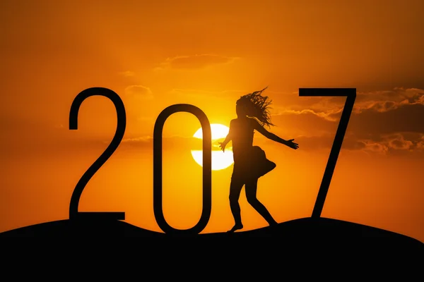 Silhouette person jumping over 2017 on the hill at sunset — Stock Photo, Image