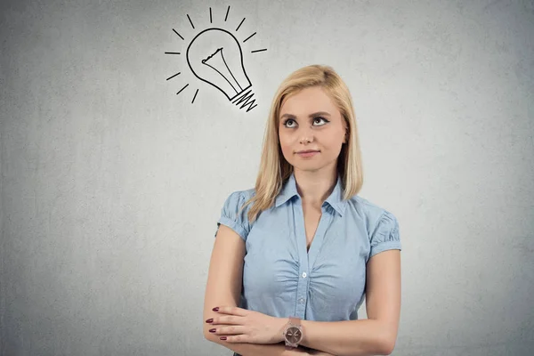 Jonge vrouw met een idee met gloeilamp boven haar hoofd glimlachen — Stockfoto