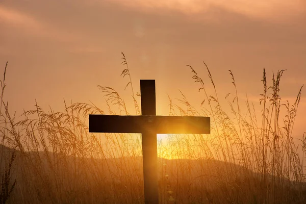 Християнський хрест силует на фоні заходу сонця — стокове фото