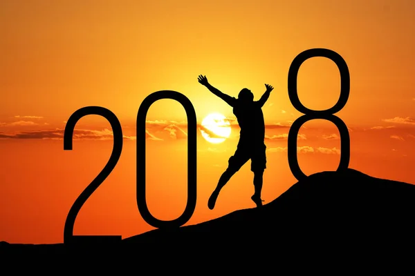 Silhouette person jumping over 2018 on the hill at sunset — Stock Photo, Image