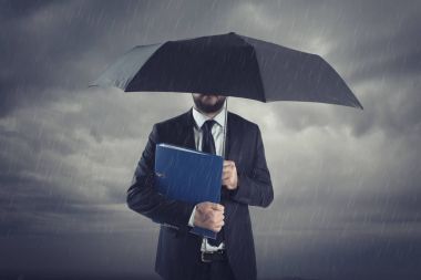 İşadamları ile fırtınalı yağmur şemsiye ayakta. Sigortacı ve iş kriz durumu danışman.