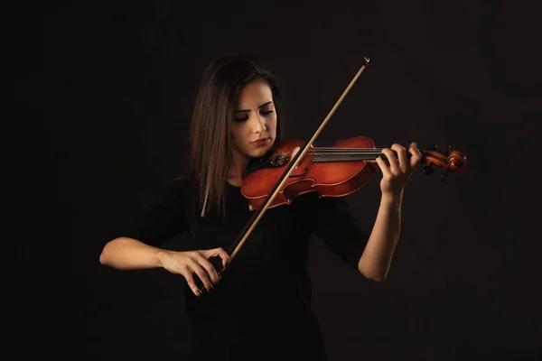 Mulher violinista bonita tocando violino no fundo preto — Fotografia de Stock
