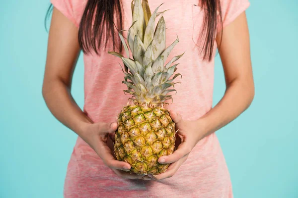 Weibliche Hand hält reife Ananas — Stockfoto