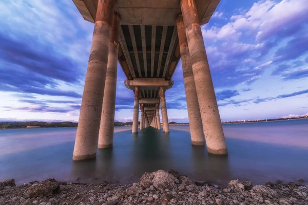 Un paesaggio a lunga esposizione di bellissimo tramonto in fiamme sotto il ponte — Foto Stock