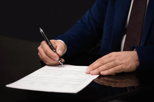 Primer plano del empresario sentado en la mesa y firmando el documento — Foto de Stock
