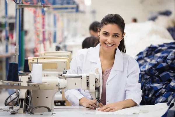 Pozitif genç kadın ile profesyonel makine Atölyesi'nde dikiş