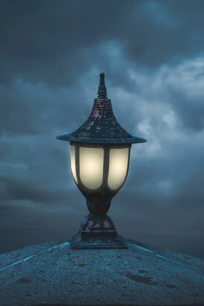 Straßenlaternen und Lichter gegen blauen wolkenverhangenen Abendhimmel — Stockfoto