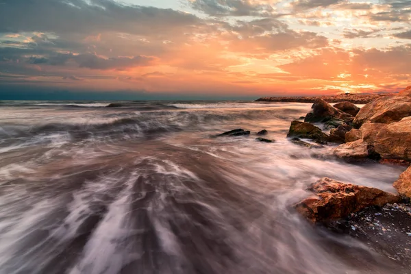 Sunrise over the sea. Stone on the foreground — Stock Photo, Image