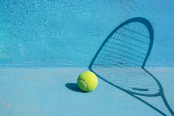 Tennisboll och racket på blå domstolen. Sport-konceptet. — Stockfoto