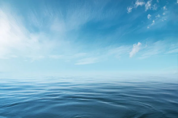 Blauwe zee of oceaan met zonnige en bewolkte lucht — Stockfoto