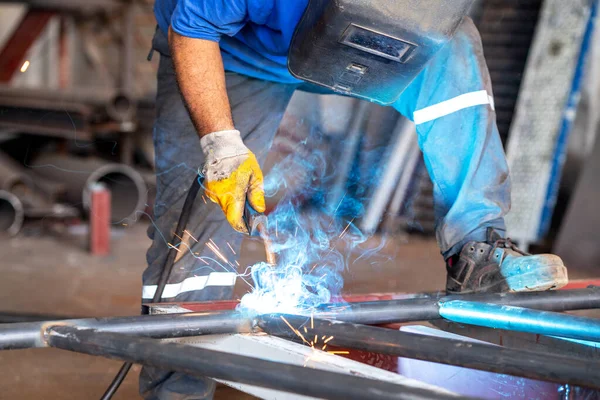 Trabalhador de metal está soldando metais com proteção de si mesmo — Fotografia de Stock