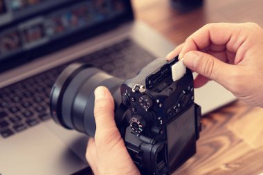 Profesyonel kameraya hafıza kartı yerleştiren ya da kaldıran fotoğrafçı 