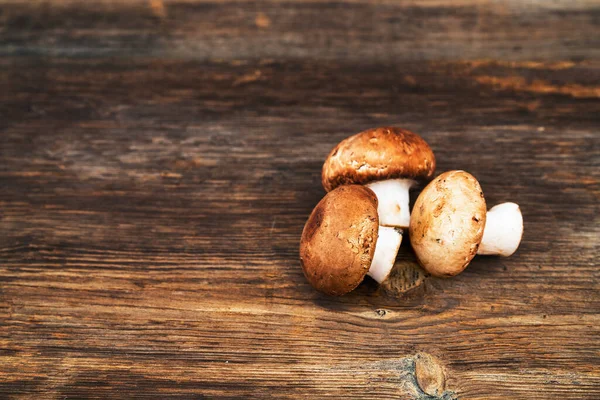 Pile of delicious champignon mushrooms on wooden background — Stock Photo, Image