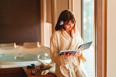 Kadın dergi okurken masaj merkezini bekliyor.