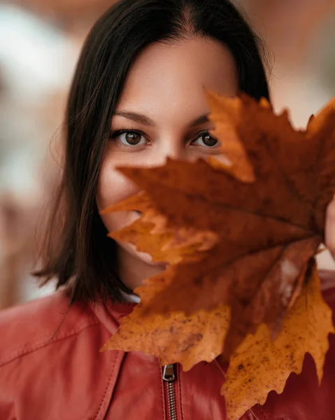Hermosa mujer disfrutando en el parque o el bosque y buscando fascinante con hojas en la mano —  Fotos de Stock