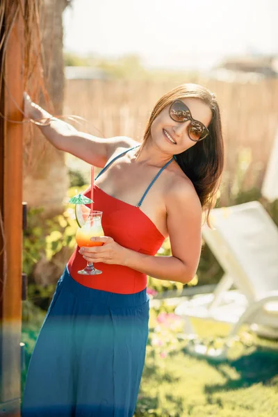 Привлекательная женщина наслаждается своим напитком на пляже в свой отпуск — стоковое фото
